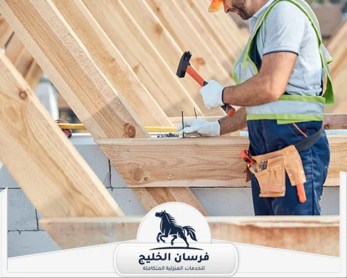 اسعار نجار في الفجيرة 0547761153 فرسان الخليج فني نجارة يعمل على تركيب عوارض خشبية ضمن هيكل إنشائي.
