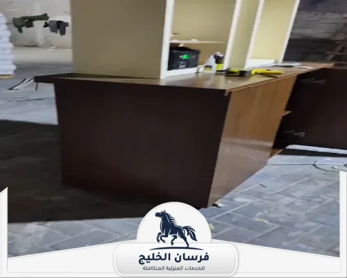 نجار فك وتركيب الاثاث في الفجيرة - فرسان الخليج تركيب كاونتر خشبي داكن مع أرفف مفتوحة في الجزء الخلفي.