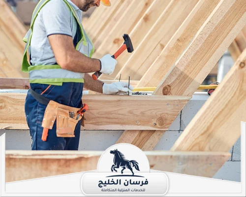 نجار مسلح في عجمان 0547761153 فرسان الخليج فني نجارة يعمل على تركيب هيكل خشبي باستخدام المسامير والمطرقة.