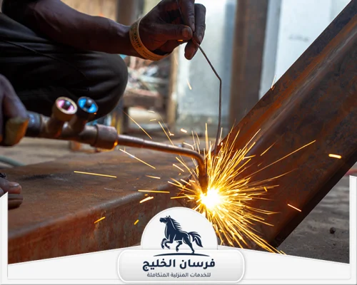 افضل حداد في عجمان 0547761153 فرسان الخليج لقطة قريبة لأعمال لحام الحديد وتثبيت الوصلات المعدنية.