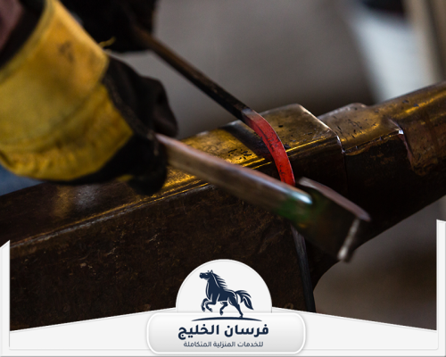 افضل حداد في دبي 0547761153 فرسان الخليج لقطة قريبة لتشكيل الحديد الساخن باستخدام أدوات الحدادة اليدوية.