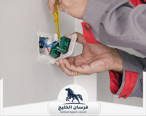 فني كهرباء يركب مفتاح حائط ويفحص الأسلاك الداخلية بدقة.
