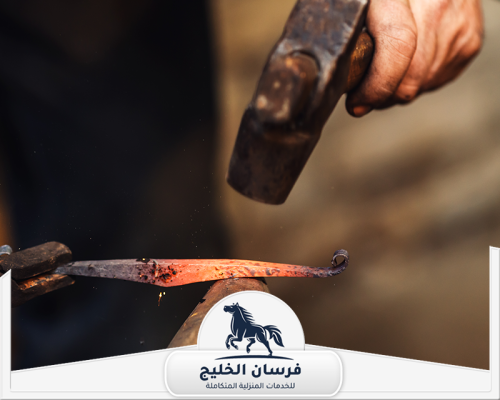 رقم حداد في الفجيرة 0547761153 فرسان الخليج قطعة حديد متوهجة يجري تشكيلها يدويًا داخل ورشة الحدادة.