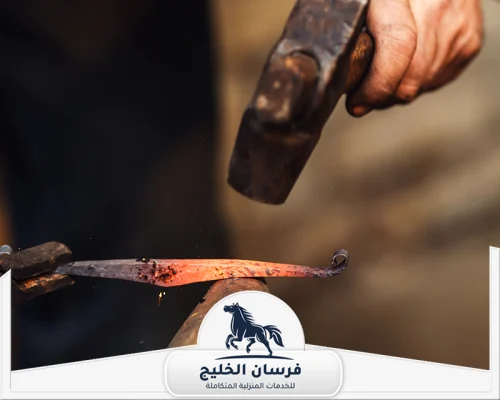 رقم حداد في الفجيرة 0547761153 فرسان الخليج قطعة حديد متوهجة يجري تشكيلها يدويًا داخل ورشة الحدادة.