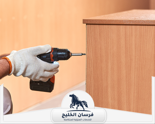 نجار تركيب غرف نوم في الفجيرة 0547761153 فرسان الخليج فني نجارة يثبت جانب خزانة خشبية باستخدام مفك كهربائي.