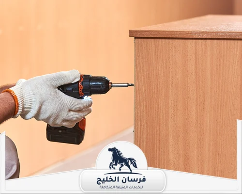 نجار تركيب غرف نوم في الفجيرة 0547761153 فرسان الخليج فني نجارة يثبت جانب خزانة خشبية باستخدام مفك كهربائي.