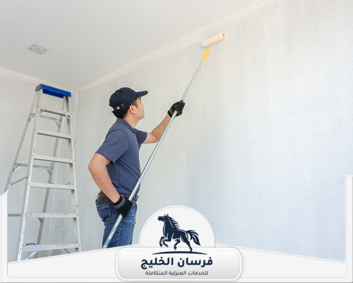 صباغ رخيص في عجمان 0547761153 فرسان الخليج عامل صباغة ينفذ دهان حائط داخلي بالقرب من السقف.