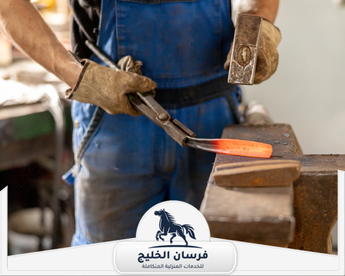 حداد بيبان في دبي 0547761153 فرسان الخليج فني حدادة يشكّل قطعة معدنية ساخنة باستخدام المطرقة والكماشة.