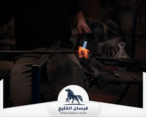 حداد ابواب في الفجيرة 0547761153 فرسان الخليج حداد يستخدم شعلة حرارية لتسخين قطعة معدنية قبل تشكيلها.