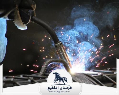 حداد ابواب في راس الخيمة 0547761153 فرسان الخليج لقطة قريبة لعملية لحام الحديد مع تصاعد الدخان والشرر داخل الورشة.
