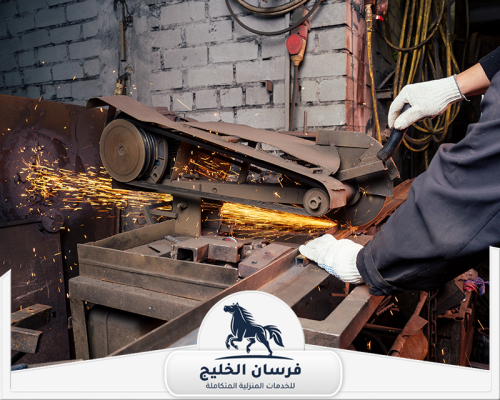 حداد ابواب في الشارقة 0547761153 فرسان الخليج عامل يستخدم منشارًا كهربائيًا لقص الحديد بدقة داخل ورشة الحدادة.