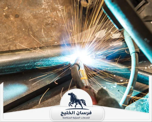 حداد هناجر في راس الخيمة 0547761153 فرسان الخليج لقطة قريبة لعملية لحام أنبوب حديدي باستخدام شعلة كهربائية.