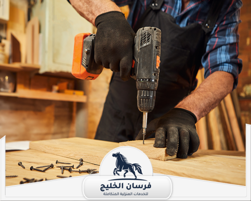 نجار اثاث منزلي في دبي 0547761153 فرسان الخليج فني نجارة يثبت الخشب باستخدام دريل كهربائي ضمن أعمال التجميع.