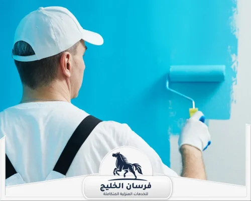 شركة صباغة في رأس الخيمة - فرسان الخليج صباغ محترف أثناء دهان جدار داخلي باللون الأزرق في رأس الخيمة.