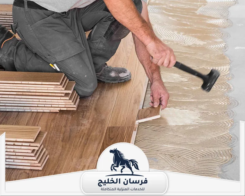 فني تركيب باركيه في دبي - فرسان الخليج فني باركيه يعمل على تثبيت الألواح الخشبية أثناء تجهيز الأرضية بشكل احترافي.