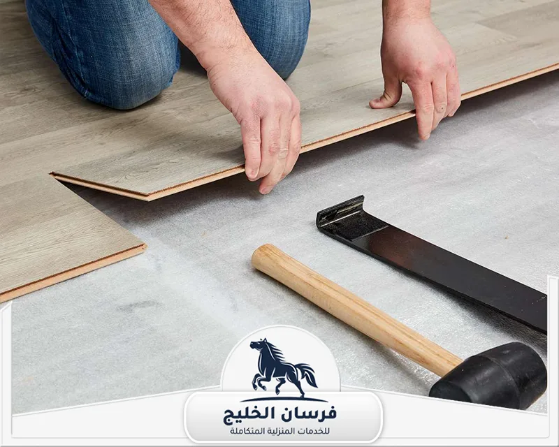 عمال تركيب باركيه في دبي - فرسان الخليج عامل يقوم بمحاذاة لوح باركيه خشبي أثناء تنفيذ أعمال تركيب الأرضيات.