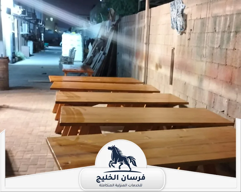 نجار خشب طاولات في أم القيوين - فرسان الخليج طاولات خشبية جاهزة موضوعة بجوار بعضها داخل موقع تنفيذ أعمال النجارة.