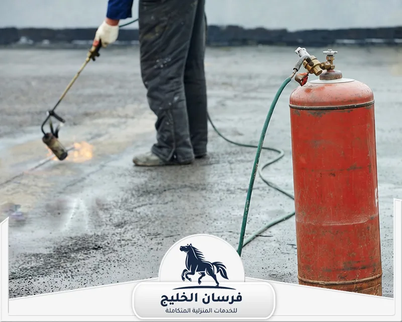العزل الحراري للأسطح في الفجيرة - فرسان الخليج عامل ينفذ أعمال عزل للأسطح باستخدام شعلة حرارية ومعدات مخصصة.