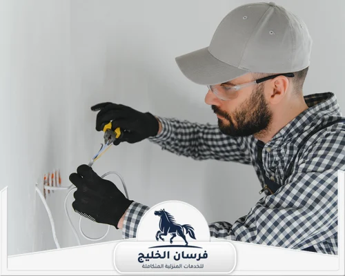 كهربائي فلل في ام القيوين - فرسان الخليج فني كهرباء يفحص أسلاك داخل الجدار باستخدام كماشة وأدوات عزل.