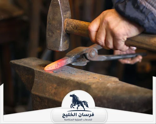 احسن حداد في الفجيرة 0547761153 فرسان الخليج فني حدادة يشكل طرف قطعة معدنية ساخنة فوق السندان.