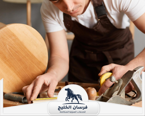 احسن نجار في دبي 0547761153 فرسان الخليج نجار يعمل على تجهيز قطعة أثاث خشبية باستخدام أدوات يدوية دقيقة.