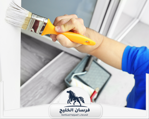 دهان رخيص فى دبى 0547761153 فرسان الخليج صباغ يطلي زاوية حائط بفرشاة صغيرة للحصول على تشطيب نظيف.