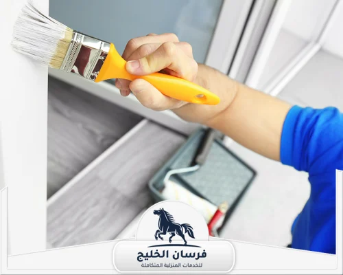 دهان رخيص فى دبى 0547761153 فرسان الخليج صباغ يطلي زاوية حائط بفرشاة صغيرة للحصول على تشطيب نظيف.