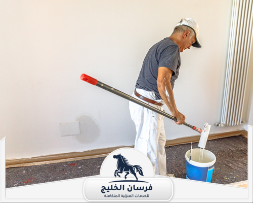 شركات اصباغ في دبي 0547761153 فرسان الخليج فني دهانات يحضر رولة الطلاء لتنفيذ صبغ جدار داخلي أبيض.