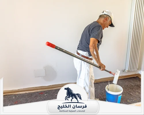 شركات اصباغ في دبي 0547761153 فرسان الخليج فني دهانات يحضر رولة الطلاء لتنفيذ صبغ جدار داخلي أبيض.
