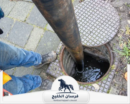 شركة تنظيف مجاري في دبي - فرسان الخليج خرطوم شفط داخل فتحة صرف مفتوحة لتنفيذ أعمال تنظيف المجاري.