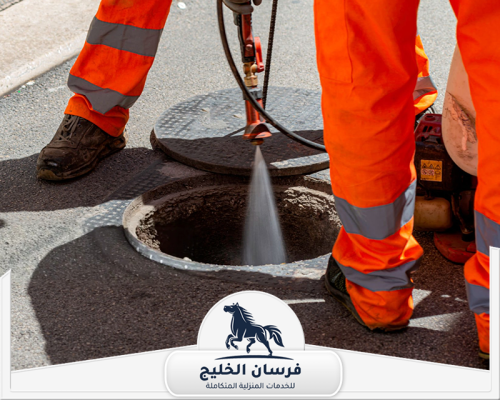 عامل تسليك مجاري في دبي 0547761153 فرسان الخليج عامل صرف صحي يستخدم ضغط المياه لتنظيف فتحة مجاري مفتوحة في الطريق.
