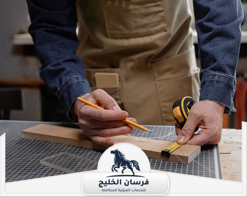 نجار في السيوح 0547761153 فرسان الخليج نجار يضع علامات القياس على الخشب استعدادًا للتفصيل والتركيب.