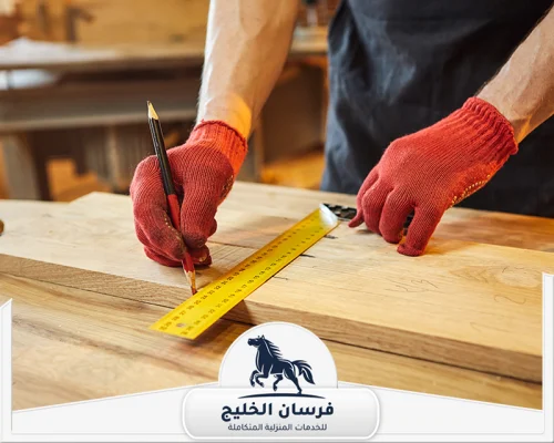 اسعار نجار في الشارقة - فرسان الخليج فني نجارة يستخدم المسطرة والقلم لضبط مقاسات الخشب بدقة.